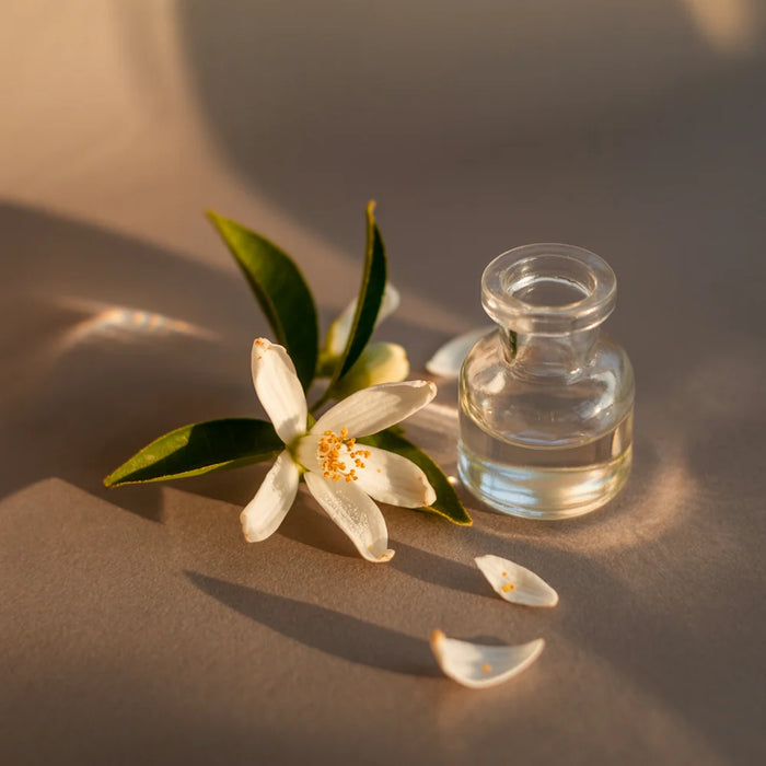 Small glass bottle with a floral arrangement on a beige surface
