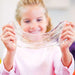 Child holding a stretchy, colorful slime in front of a blurred background