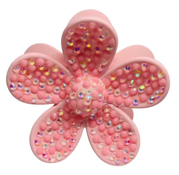 Pink flower-shaped object with glittery beads on a white background
