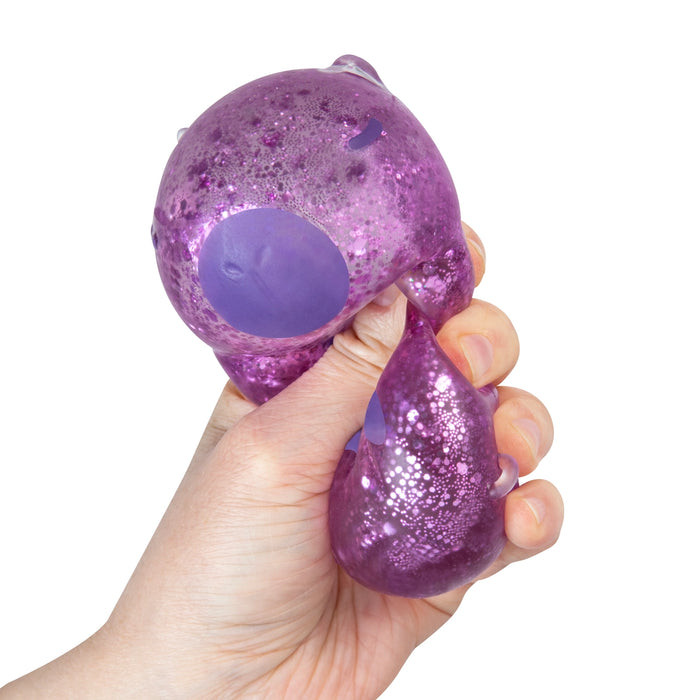 Hand holding a purple glittery stress ball against a white background