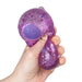 Hand holding a purple glittery stress ball against a white background
