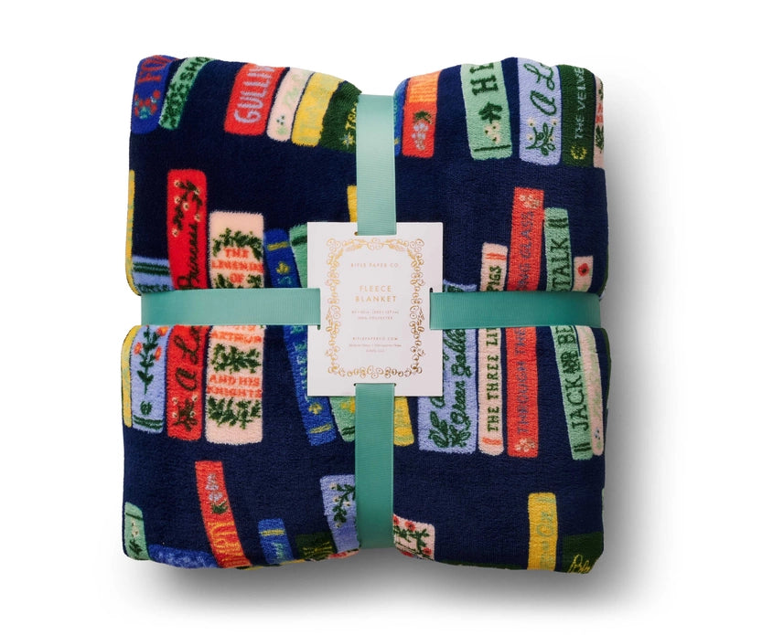 Folded blanket with book design and visible brand label on a white background