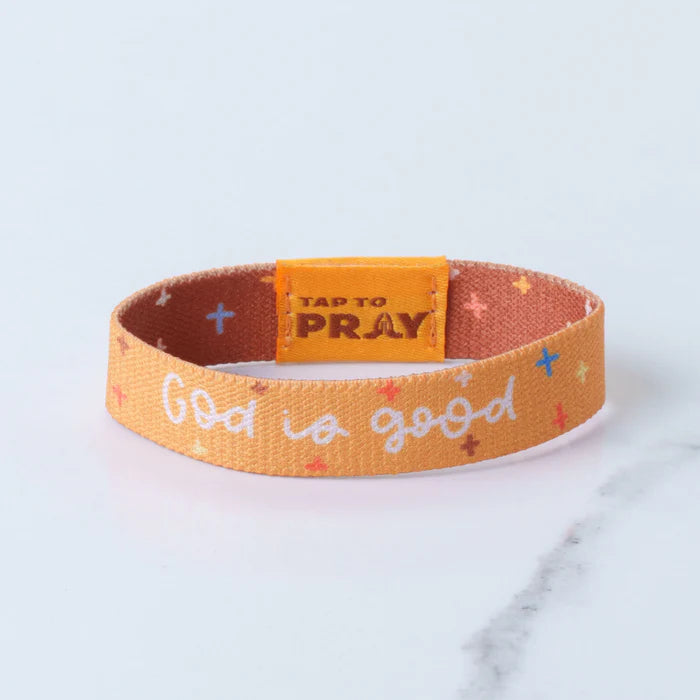 Orange wristband with 'God is good' text and 'Tap to Pray' button on a light blue background