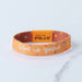 Orange wristband with 'God is good' text and 'Tap to Pray' button on a light blue background