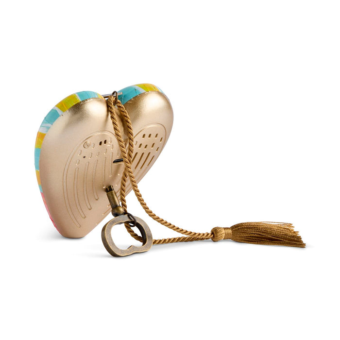 A heart-shaped gold metallic perfume atomizer case with a colorful patterned backing, a gold rope handle, and a tassel, shown on a white background.