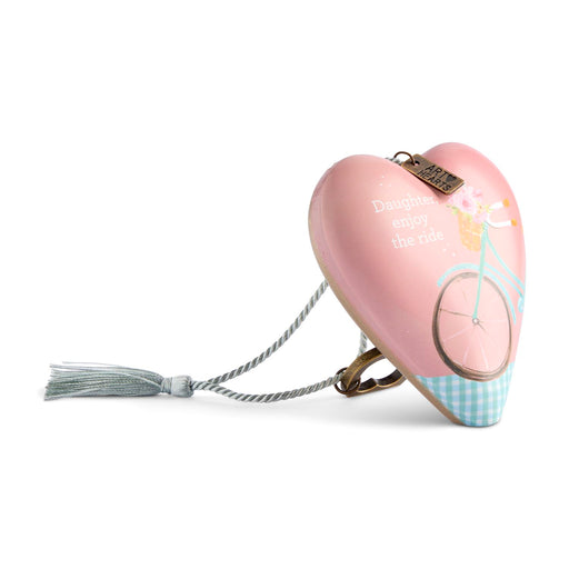 A heart-shaped pink safety keychain case with a bicycle illustration, the text 'Daughter, enjoy the ride,' a tassel, and a metal clip, shown on a white background.