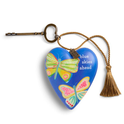 Heart-shaped keychain with butterflies and 'blue skies ahead' text on a white background