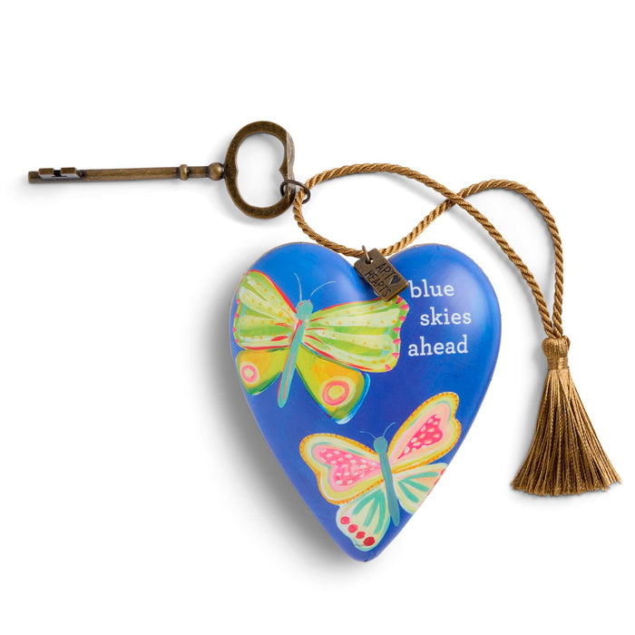Heart-shaped keychain with butterflies and 'blue skies ahead' text on a white background