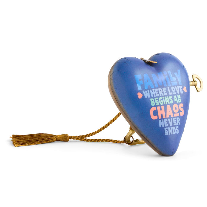A heart-shaped wooden wall hanging with a blue painted surface, gold-toned metal hardware, a braided gold hanging cord, and a tassel. The heart features the text 'FAMILY WHERE LOVE BEGINS AS CHAOS NEVER ENDS' in light blue, white, and orange lettering.