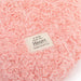 Pink textured blanket with a label reading 'A Hug from the Heart' on a white background