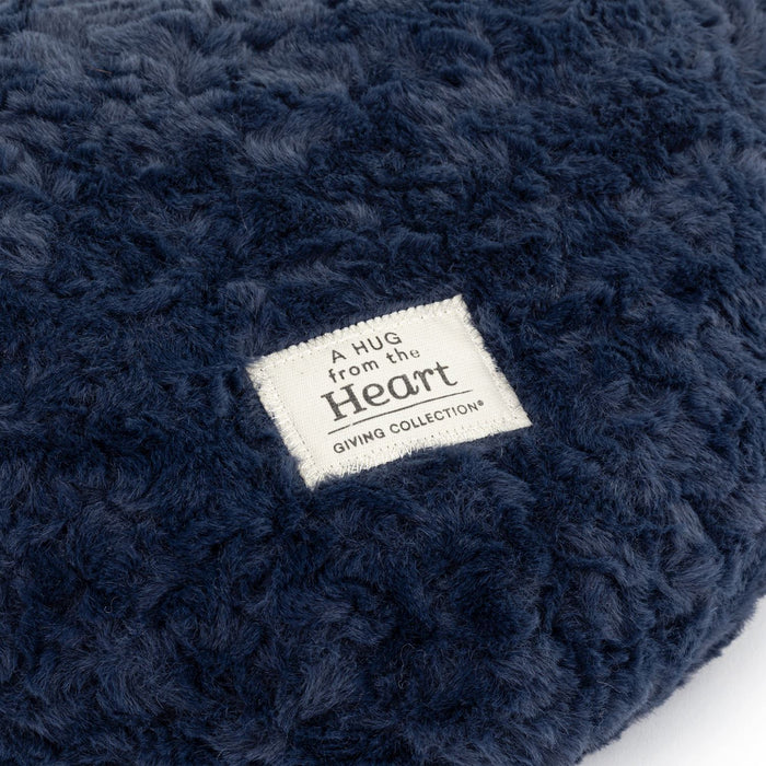 Navy blue textured product with a label reading 'A Hug from the Heart' on a white background