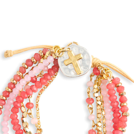 Set of beaded bracelets with gold accents and a cross charm on a white background