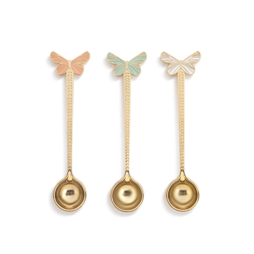 Three gold spoons with butterfly ends on a white background