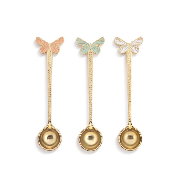 Three gold spoons with butterfly ends on a white background