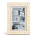 A rectangular picture frame with a cream-colored border featuring a repeating gold butterfly pattern, holding a black-and-white photo of wall frames and decor.