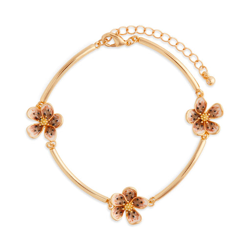 Gold bracelet with floral charms on a white background