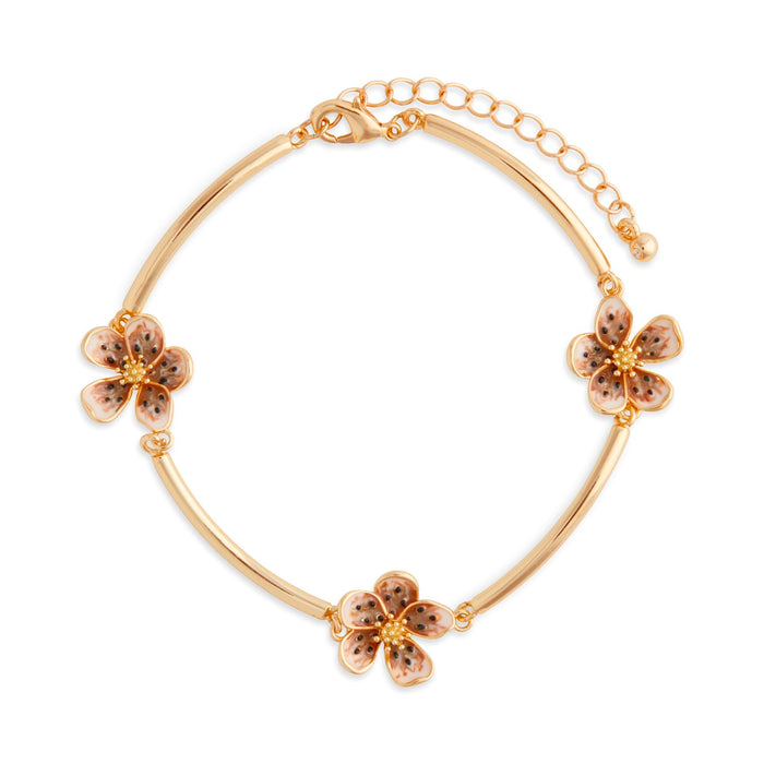 Gold bracelet with floral charms on a white background