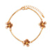 Gold bracelet with floral charms on a white background