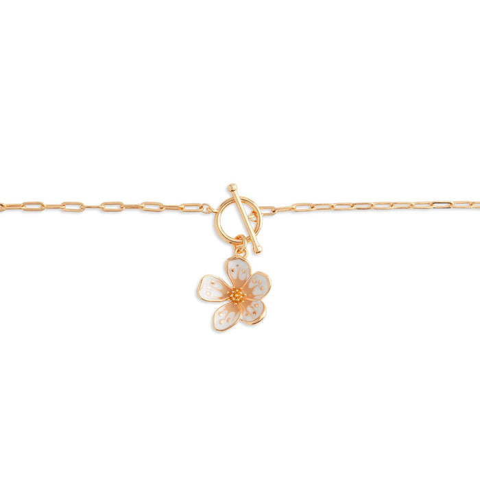 Gold bracelet with a floral charm on a white background