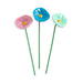 Three ceramic flowers in pink, blue, and green on a white background