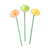 Three ceramic flowers in peach, green, and yellow on a white background