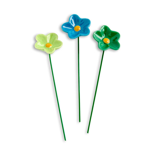 Three colorful glass flowers on sticks against a white background