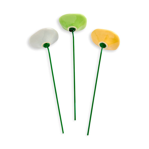 Three ceramic flowers with green stems on a white background
