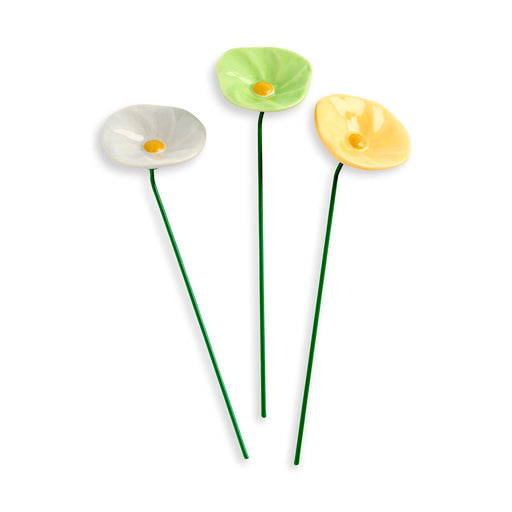 Three ceramic flower-shaped planters in green, yellow, and white on a white background