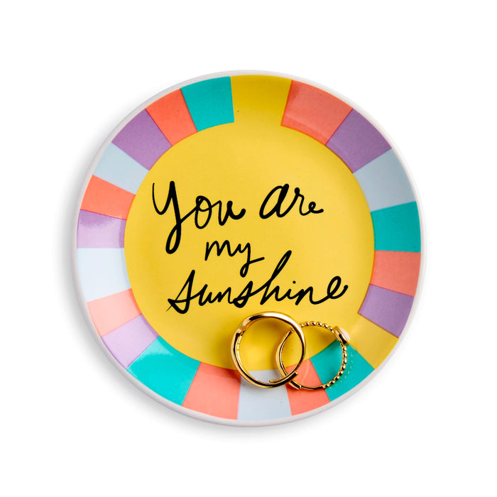Round ceramic trinket dish with colorful rim and 'You are my sunshine' text, holding two gold rings.