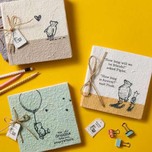 Three notebooks with Winnie the Pooh illustrations on a yellow background