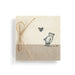Small wrapped gift with string and a heart on a white background