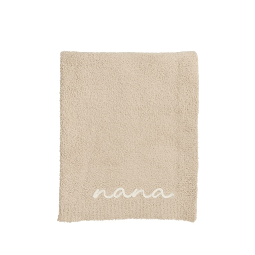 Beige blanket with 'nana' embroidery on a white background