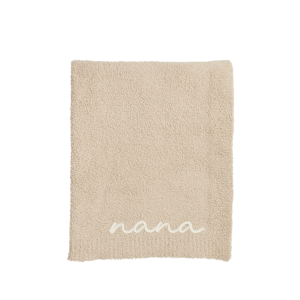 Beige blanket with 'nana' embroidery on a white background