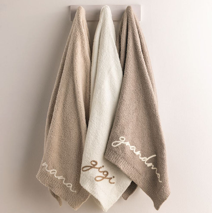 Three towels with embroidered names 'mom', 'jiji', and 'grandma' on a neutral background