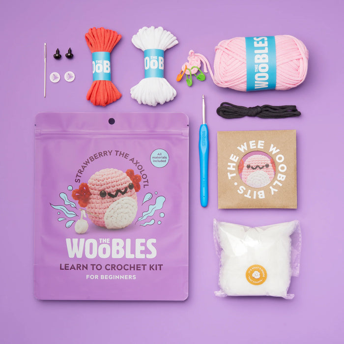 Crochet kit with yarn, hooks, and packaging on a purple background