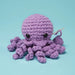 Purple knitted octopus toy on a light blue background