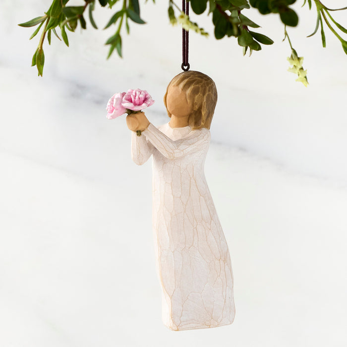 Decorative angel figurine holding a pink flower against a white background