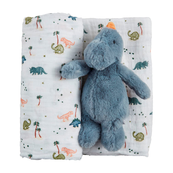 Blue dinosaur plush toy on a white blanket with dinosaur patterns