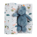 Blue dinosaur plush toy on a white blanket with dinosaur patterns