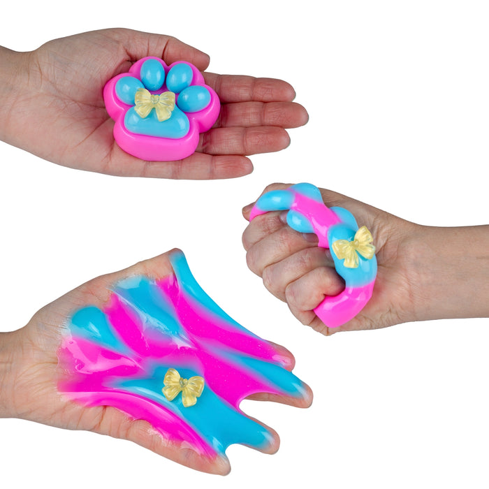 Three views of a pink and blue paw-shaped slime toy with a small gold bow detail, shown being held and stretched on a white background.