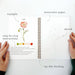 Open notebook with watercolor paper, poppy illustration, and step-by-step instructions on a white background.