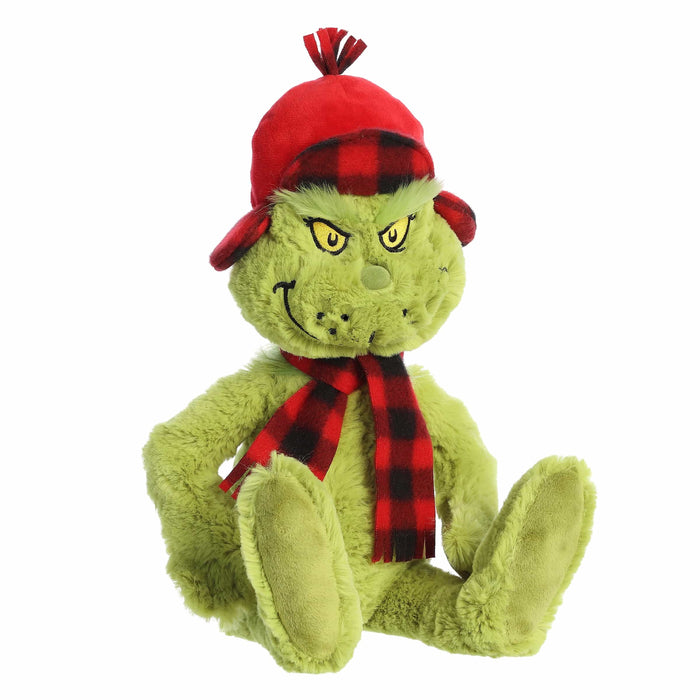 Plush toy resembling a green character with a red hat and scarf on a white background