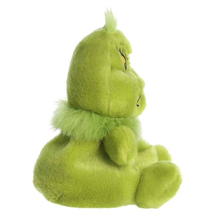 Green plush toy with a sad expression on a white background
