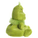 Green plush toy with a sad expression on a white background