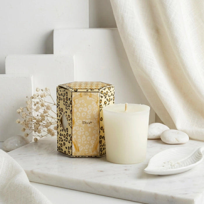 Decorative candle with leopard print packaging on a marble surface with a neutral background