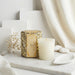 Decorative candle with leopard print packaging on a marble surface with a neutral background
