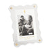 White photo frame with gold accents holding a family photo, on a white background
