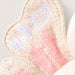 Close-up of a knitted fabric with pink and beige colors on a light background