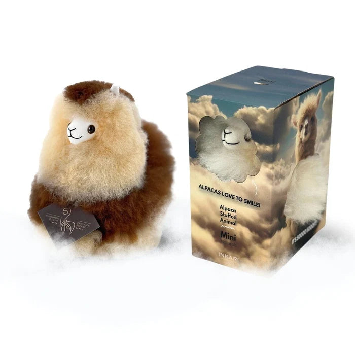 A plush alpaca toy next to its retail box on a white background. The toy is fluffy with a cream-colored body, brown head and legs, and a small white snout.