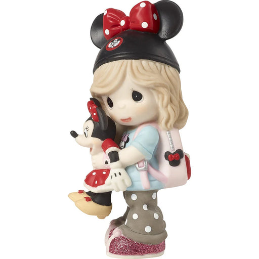 A Precious Moments collectible figurine of a young girl with blonde hair wearing a black Minnie Mouse hat with a red polka-dot bow, holding a small Minnie Mouse doll. She has a pink backpack with a Minnie Mouse head detail and glittery grey polka-dot tights, set against a plain white background.